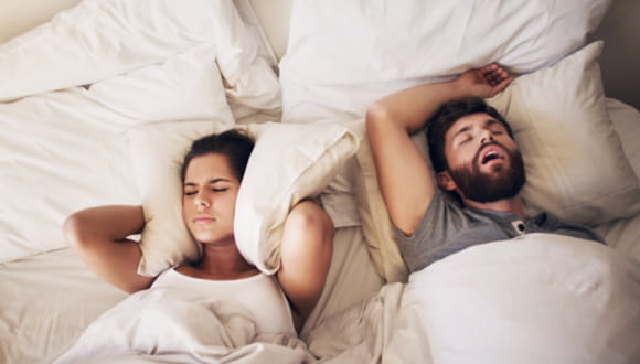 man snoring next to woman