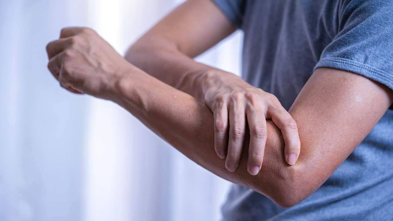 person with shooting pain down their arm, a symptom of radiculopathy