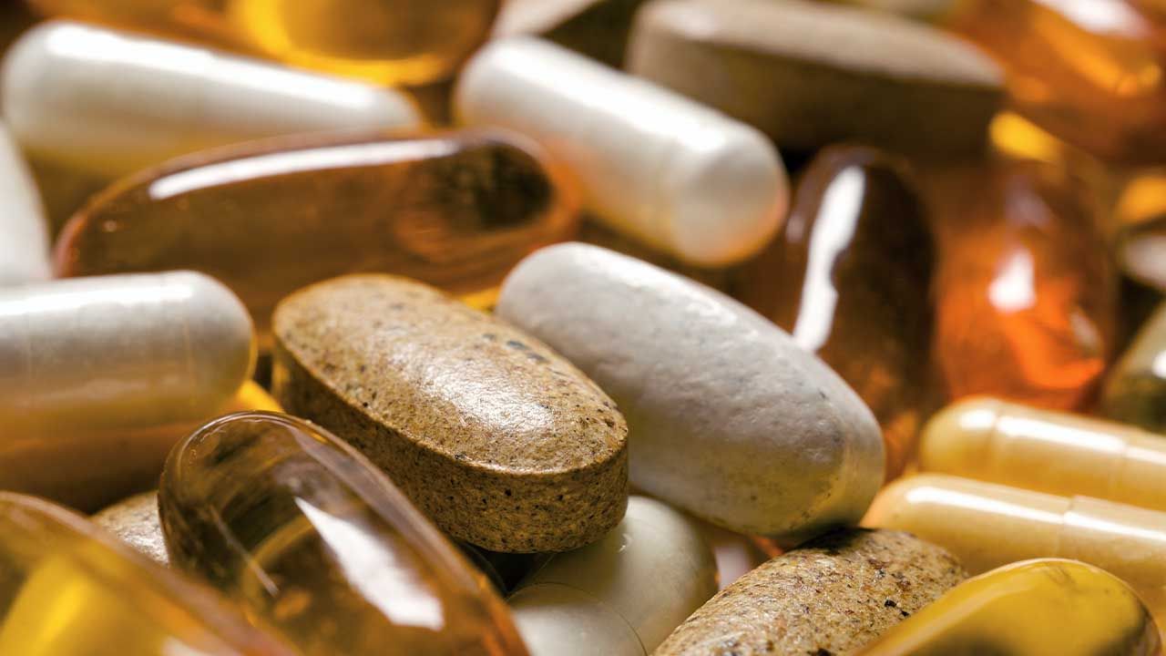 Assortment of dietary supplements, including capsules, tablets and softgels, shown in close-up.