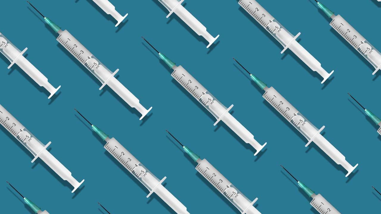 A group of medical needles on a teal background. 