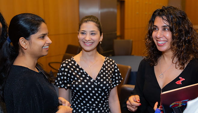 Two female medical residents talk to Dr. Martha Gulati.