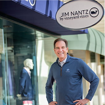 Jim Nantz standing in front of vineyard vines storefront
