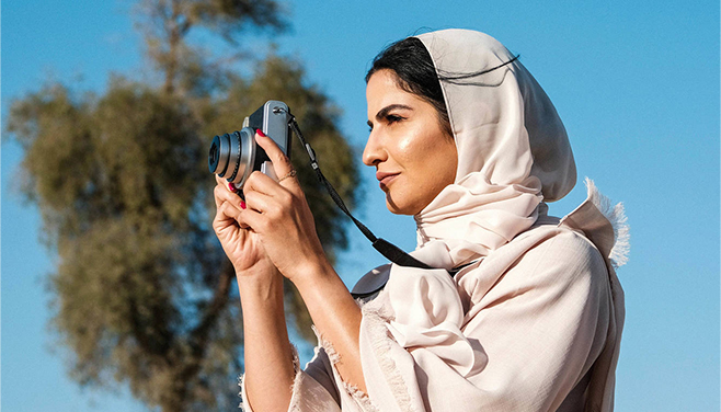 Women with hijab holding camera