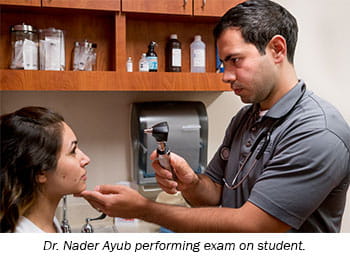 Dr. Nader Ayub performing exam on student