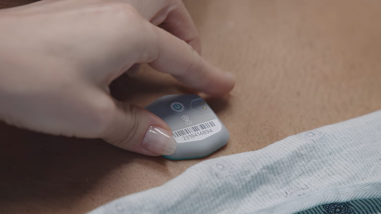 A wearable device held against a patient.