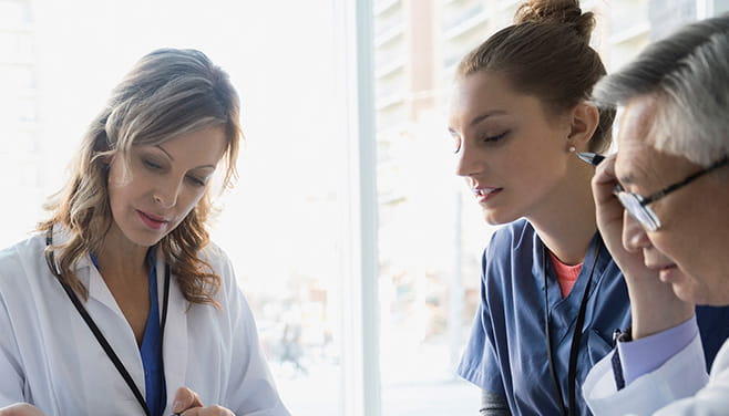 three medical professionals at a meeting