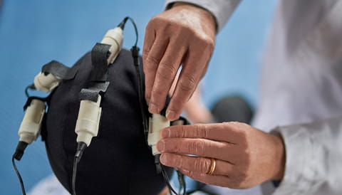 doctors hands adjusting electromagnetic cap