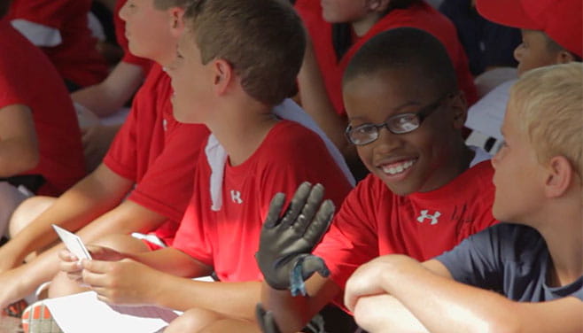 children athletes sitting listening and smiling