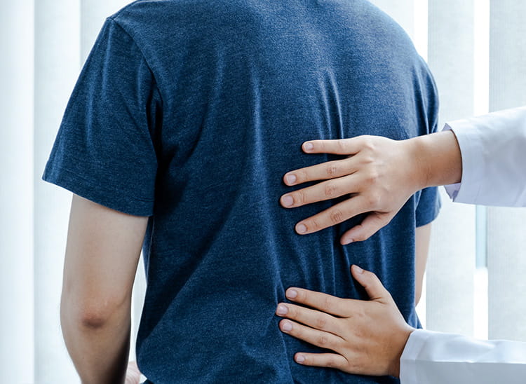 Doctor examining a patient’s back during a medical checkup