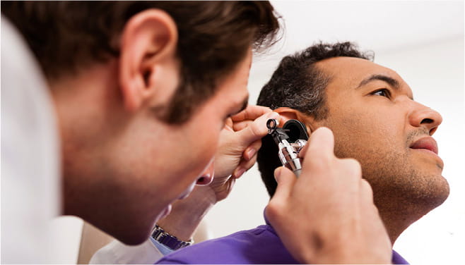 ENT doctor examining patient’s ear with an otoscope at Houston Methodist