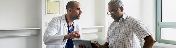 a male doctor discusses the advanced heart failure program with his older male patient