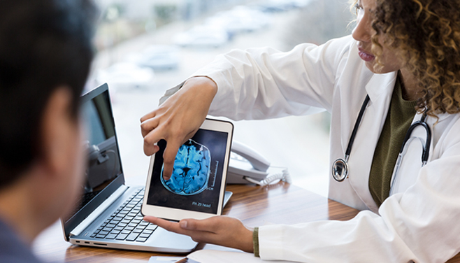 Doctor explaining brain scan on tablet to patient