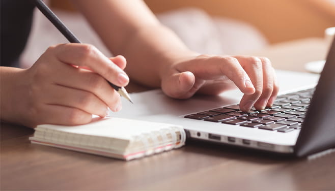 patient researching on laptop and taking notes