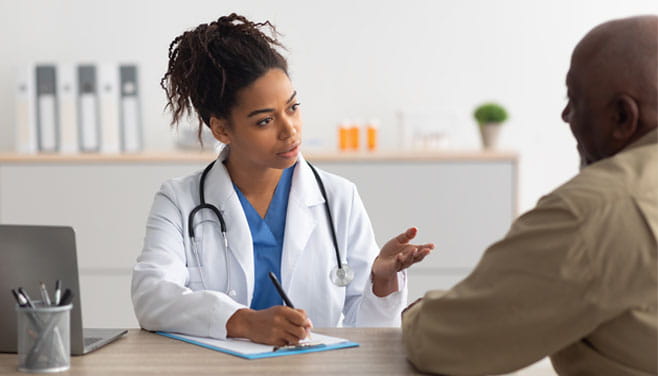 doctor sitting at desk facing patient conversing