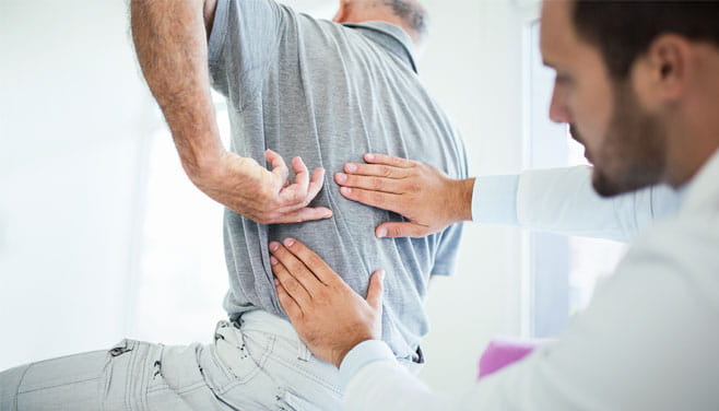 doctor examining patient's lower back