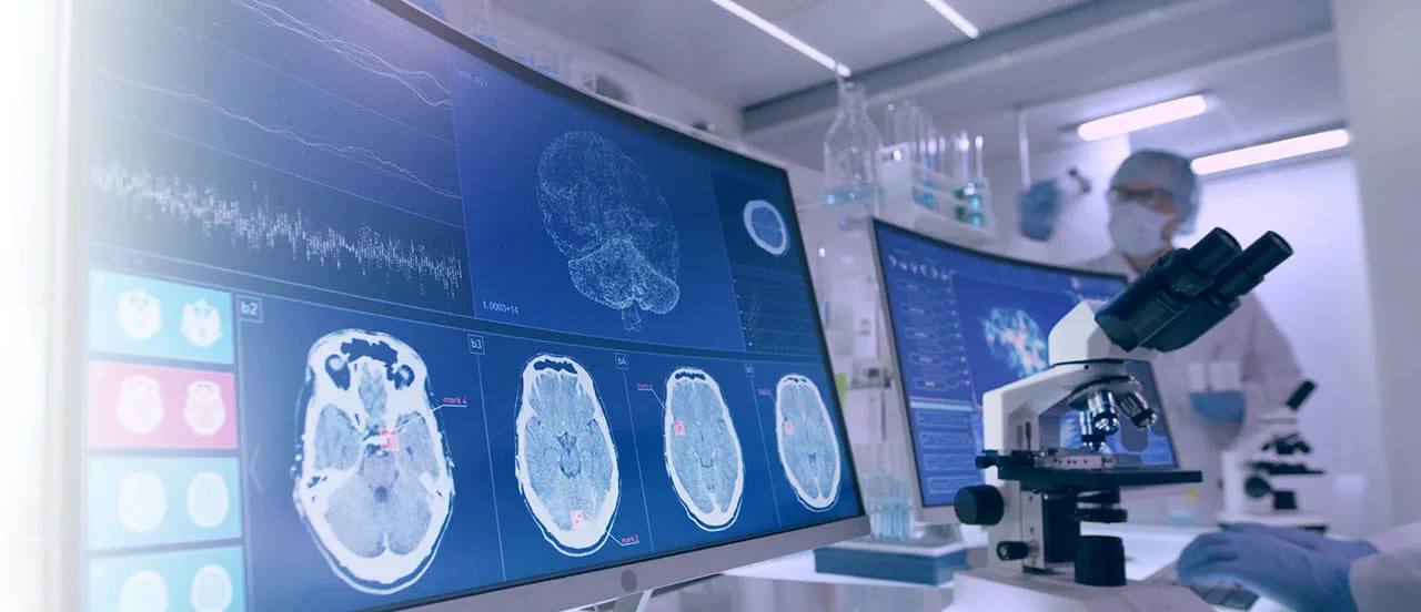 2 monitors with brain scan imagery on them, with a telescope centered between them