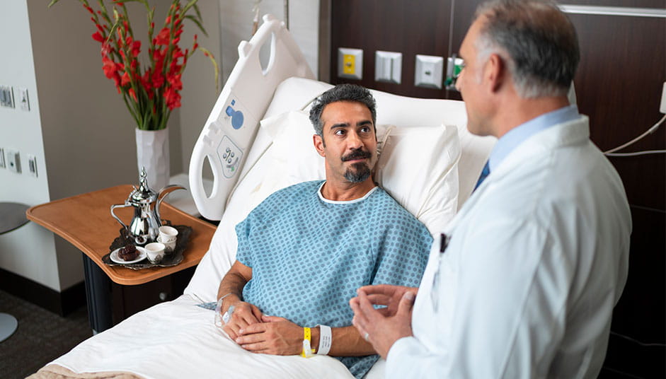 male patient in bed with doctor at the bedside