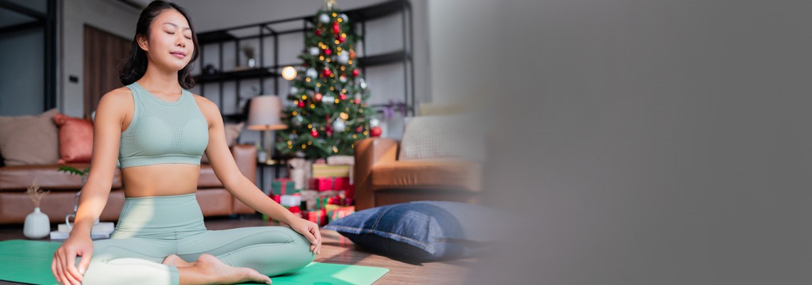 Women doing yoga with Christmas tree in the background