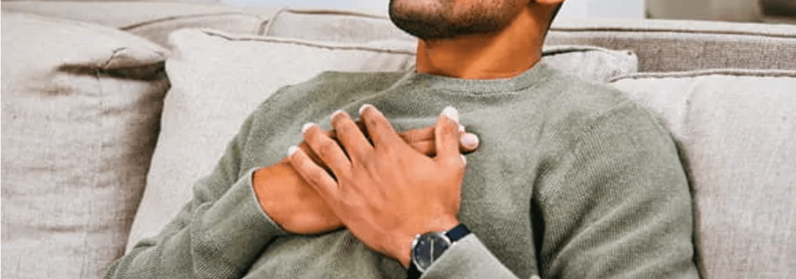 man with hands to his chest