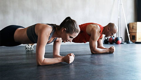 Man and women doing a plank exercise 